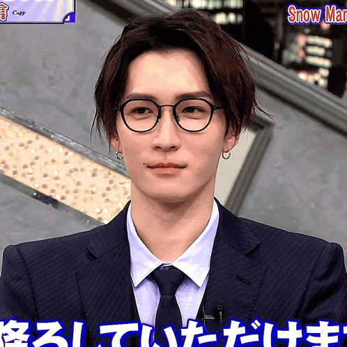a man wearing glasses and a suit has the word snow on the bottom