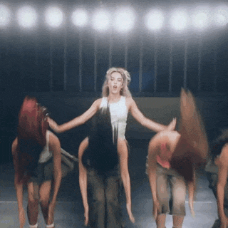 a group of people are dancing in a dark room
