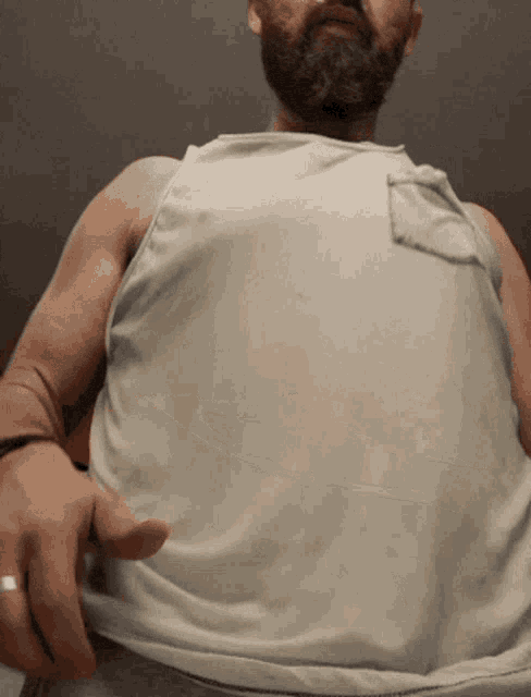 a man with a beard and a white tank top