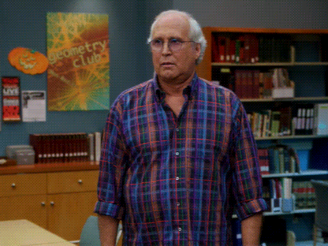 an older man in a plaid shirt is standing in front of a geometry club poster