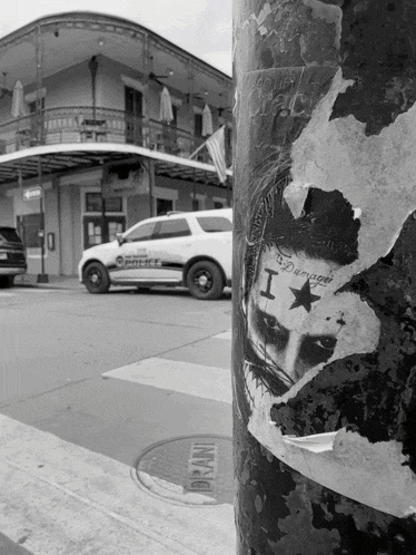 a black and white photo of a police car with a sticker on it that says i am damaged
