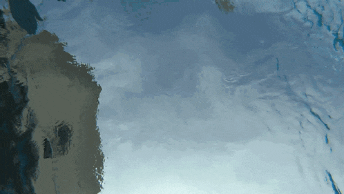 a reflection of a building in the water with a cloudy sky in the background