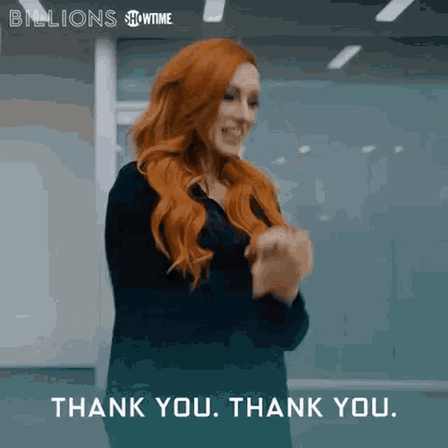 a woman with red hair is clapping her hands and says thank you .