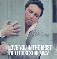 a man is hugging another man behind a wall with the words `` i love you in the most heterosexual way '' .