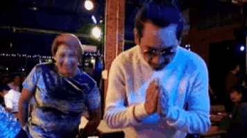 a man and a woman are praying with their hands folded