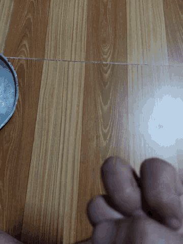 a person 's hand is reaching out towards a wooden surface