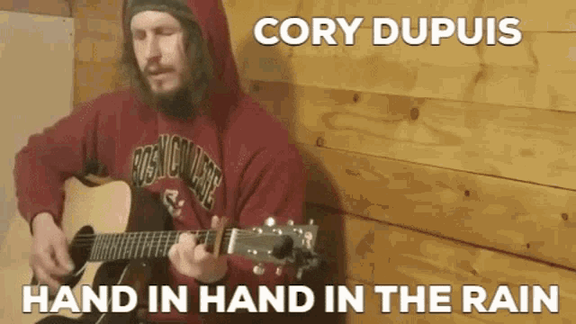 a man playing a guitar with the words cory dupuis hand in hand in the rain above him