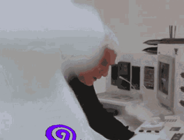 a person sitting in front of a computer with purple letters that say ' 2 ' on it