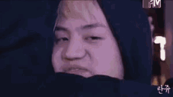 a close up of a person 's face with a hood on .