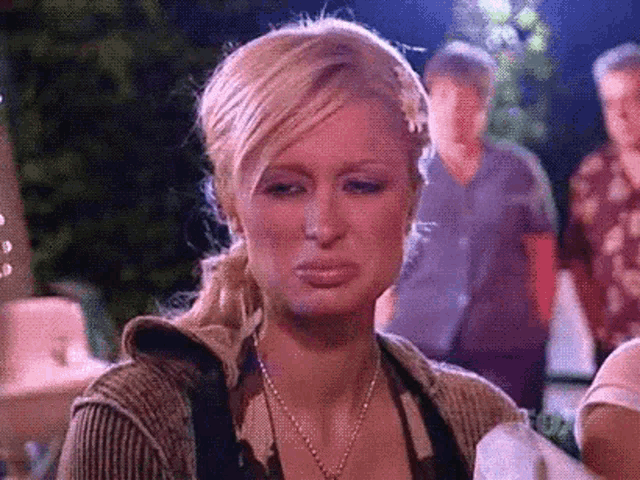 a close up of a woman making a funny face while holding a napkin .