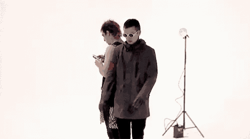 a man and a woman are standing next to each other in a white room .