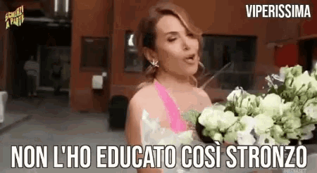 a woman holding a bouquet of flowers with the words non l' ho educato così stronzo
