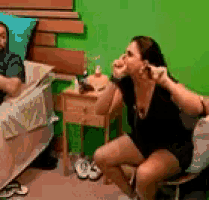 a woman is sitting on a chair in front of a man laying in a bed .