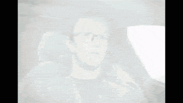 a man wearing glasses and a jacket is sitting in a car