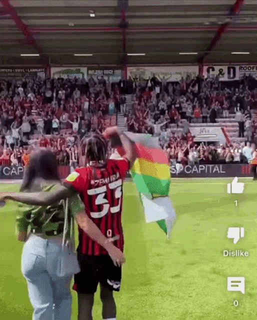 a soccer player with the number 33 on his jersey holds a flag