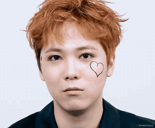a close up of a young man with a heart on his face