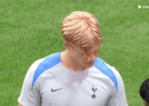 a man wearing a nike shirt with the tottenham logo on it
