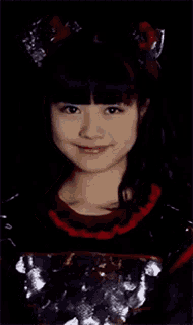 a close up of a girl 's face in a black and red outfit