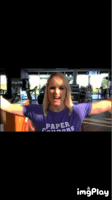 a woman wearing a purple shirt that says paper condoms on it