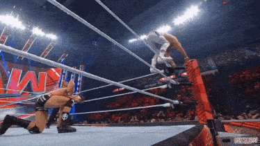 two wrestlers are in a wrestling ring with the word wwe on the wall