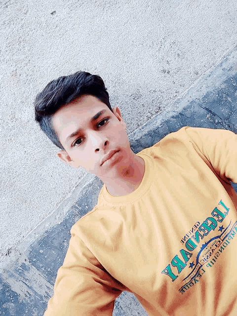 a young man wearing a yellow t-shirt that says legend