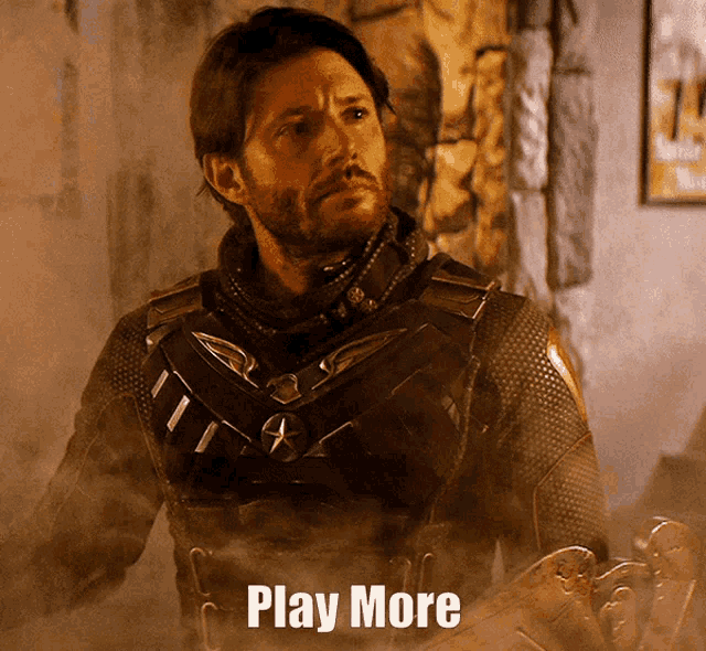 a man with a beard is standing next to a sign that says play more