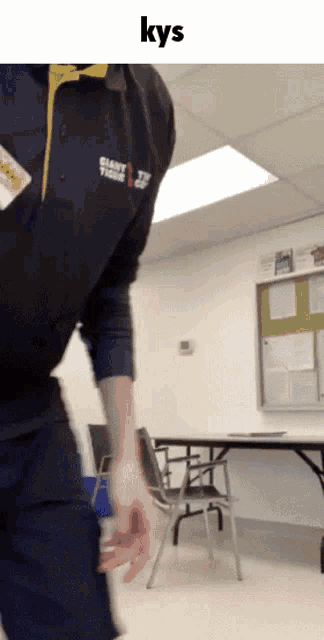 a man wearing a jacket that says giant tiger is standing in a room