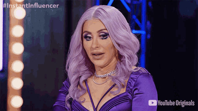 a woman with purple hair is wearing a purple dress and a youtube originals logo