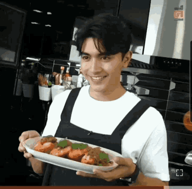 a man is holding a plate of food and smiling