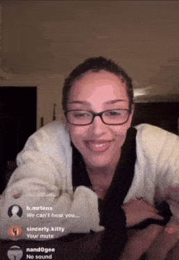 a woman wearing glasses is laying on a table with a no sound sign behind her