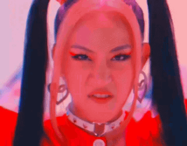 a close up of a woman with pigtails and a choker .
