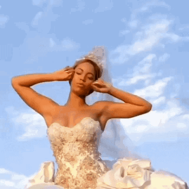 a woman in a white dress is standing in front of a body of water and a sunset .