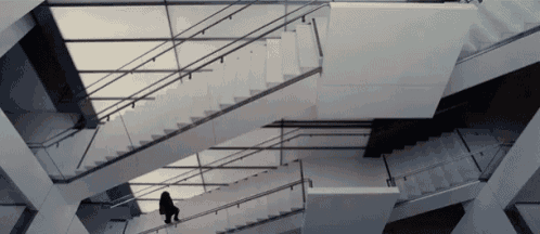 a woman is walking up a set of stairs in a building