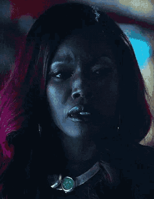 a close up of a woman with red hair and a necklace on her neck .
