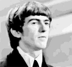 a black and white photo of a man in a suit and tie looking at the camera .