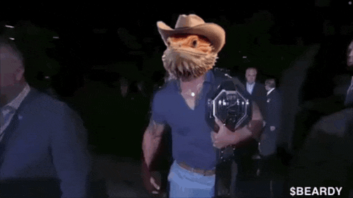 a man wearing a cowboy hat is holding a ufc championship belt