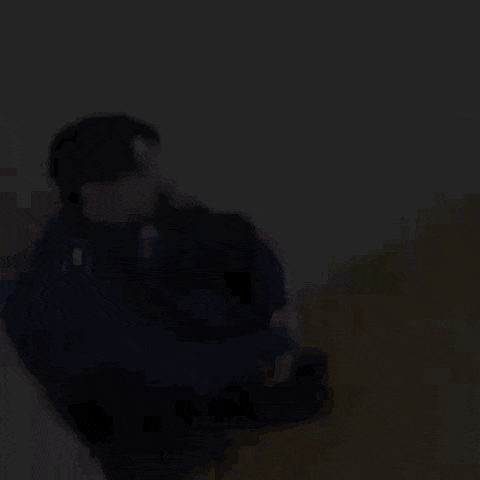 a police officer is sitting on the floor next to a wall .