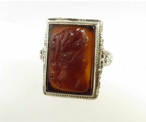a silver ring with a carved stone in the middle
