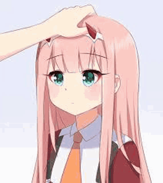 a person is putting their hand on a girl 's head .