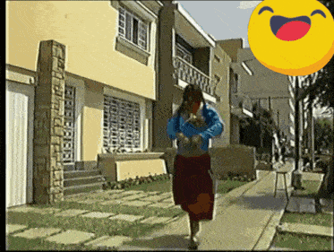 a woman is walking down a sidewalk in front of a house