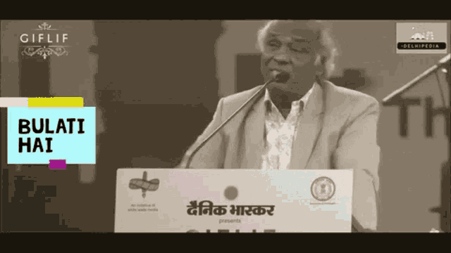 a man stands at a podium with a sign that says ' bulati hai '
