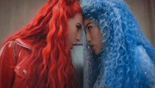 a woman with red hair and a woman with blue hair are looking at each other
