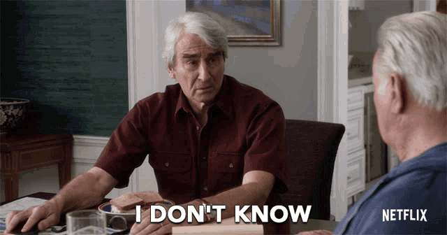 a man sitting at a table with a netflix logo on the bottom