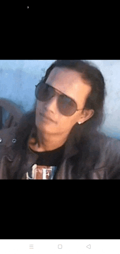 a man with long hair wearing sunglasses and a black shirt .