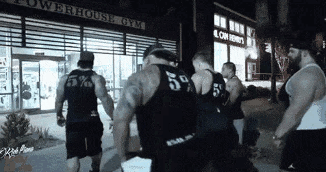 a group of men wearing black tank tops with the number 55 on them