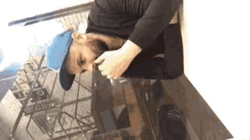 a man with a beard wearing a blue hat is laying on a table .