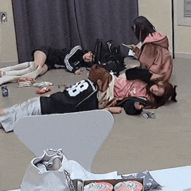 a girl with the number 88 on her shirt is laying on the floor with other girls
