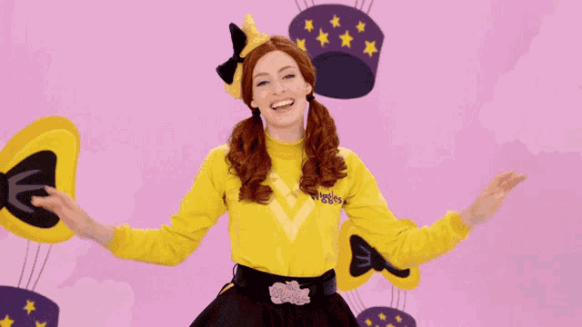 a woman wearing a yellow shirt with the letter e on it