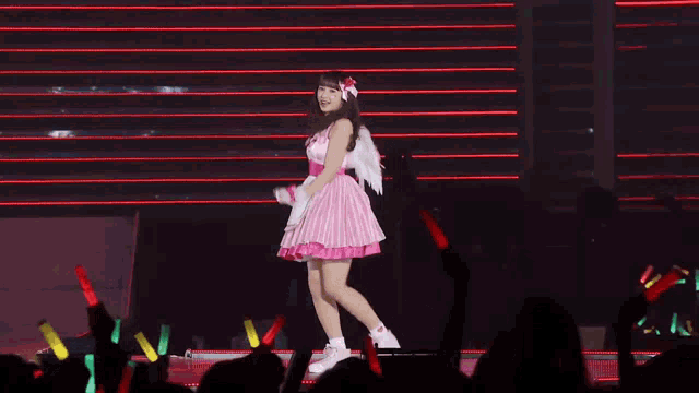 a woman in a pink and white dress is dancing on a stage