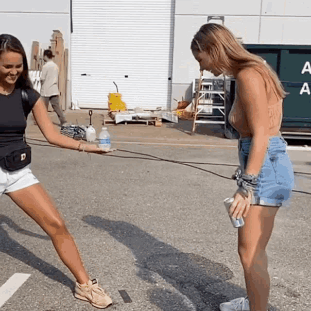 two women are standing in front of a dumpster that says aa